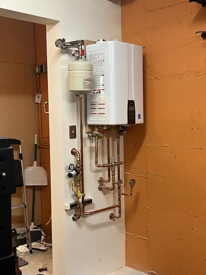 Plumbing technician inspecting water heater connections in Church Hill